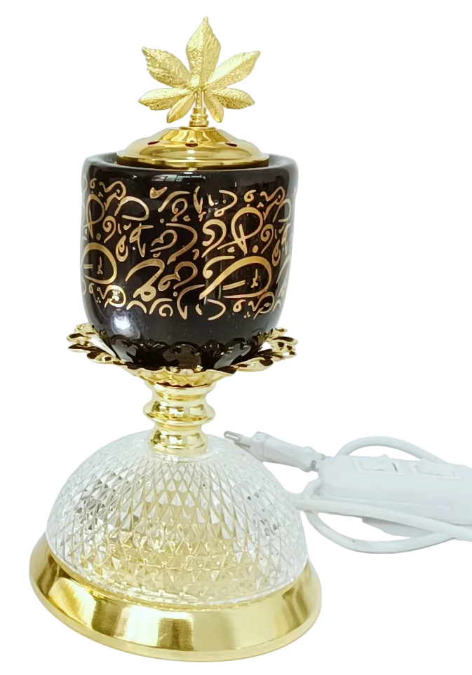 Decorative lamp and burner on black background, gold accents, and leaf design on the lid, an LED lamp below.