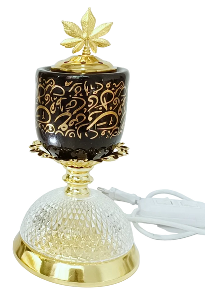Decorative lamp and burner on black background, gold accents, and leaf design on the lid, an LED lamp below.