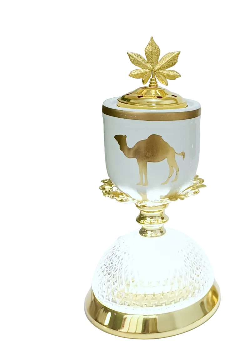 Decorative burner and lamp with gold accents and a camel design on a white surface.