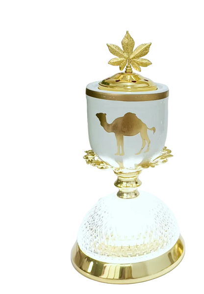 Decorative burner and lamp with gold accents and a camel design on a white surface.